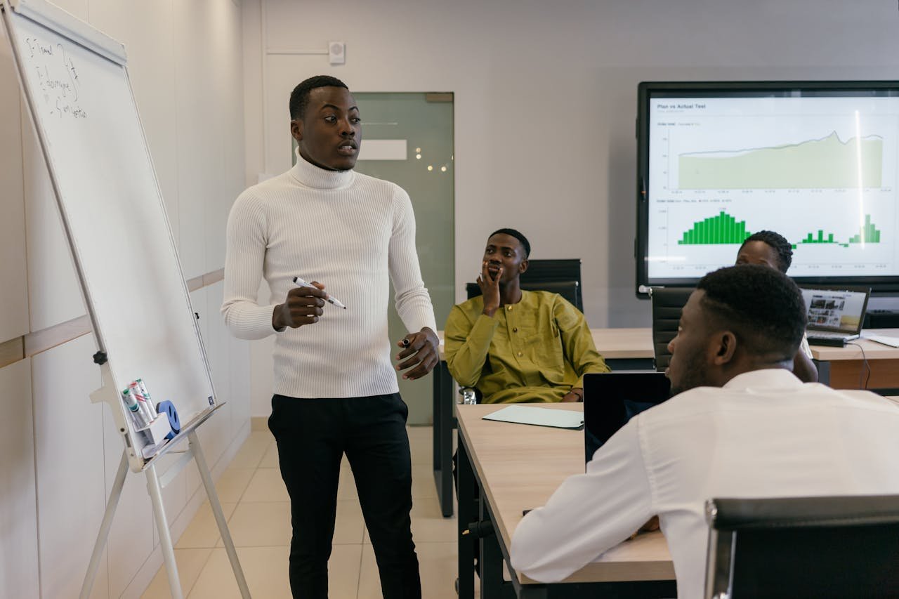 about-01 Group of professionals discussing business strategy during a presentation in a bright, modern workspace.